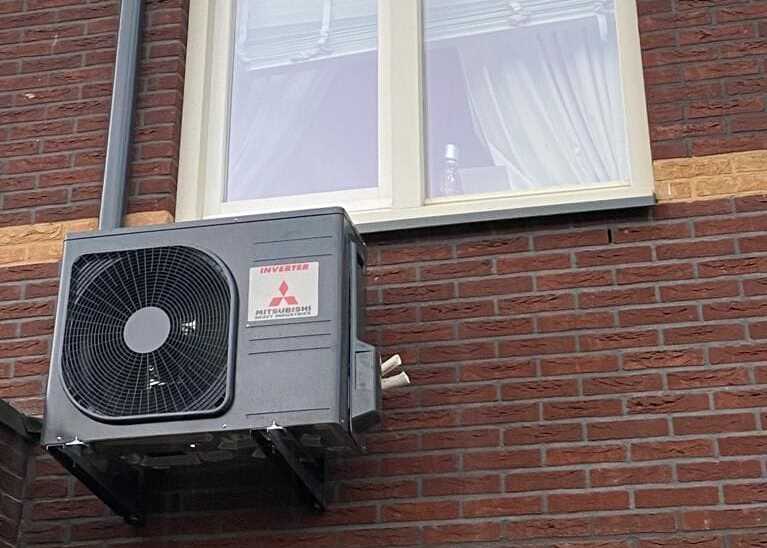 Buitenunit aan de gevel van een woning, de unit die de warmte uit de buitenlucht haalt